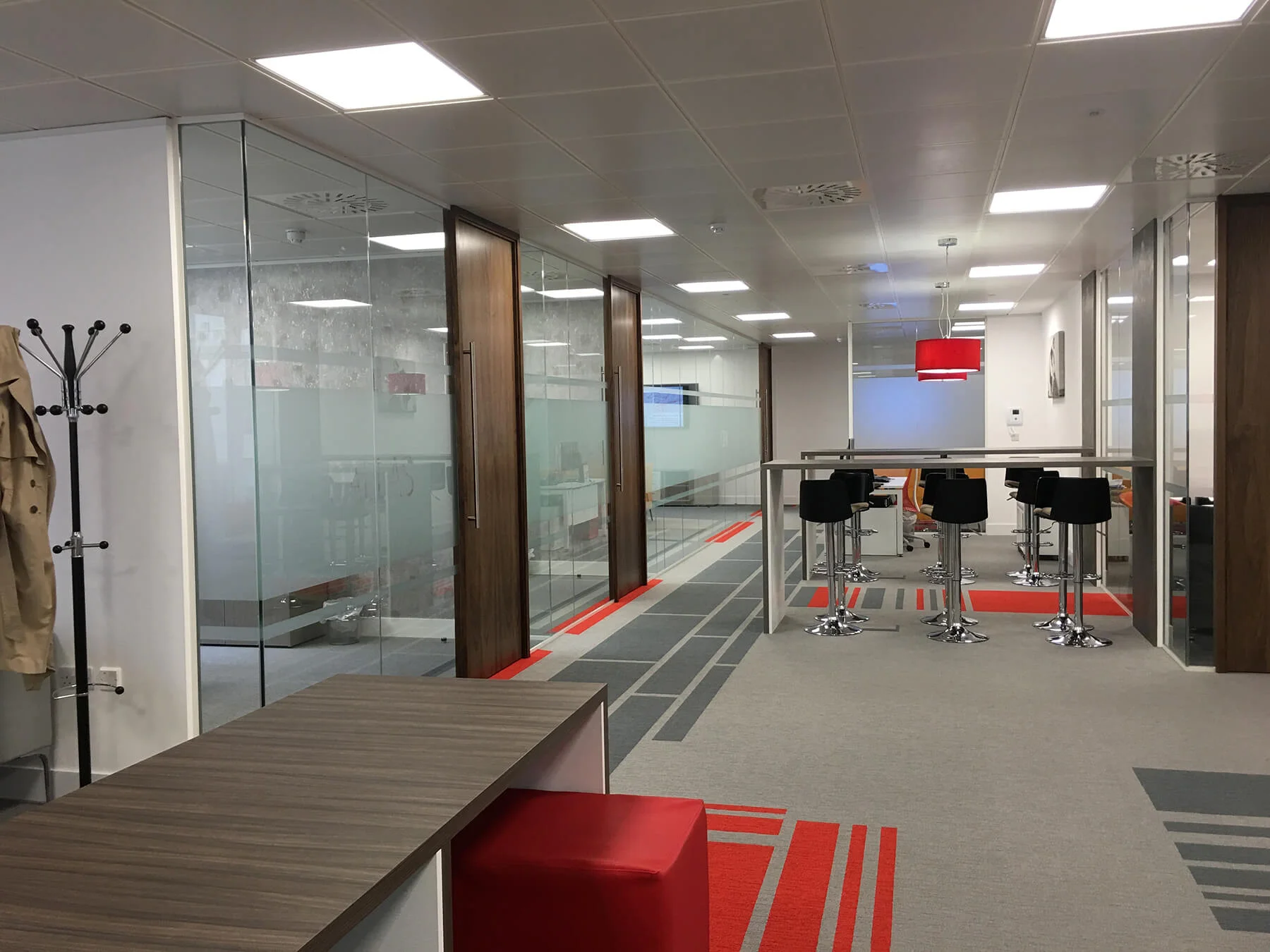 Comparex office space with high desks chairs glass partitions and designer floor