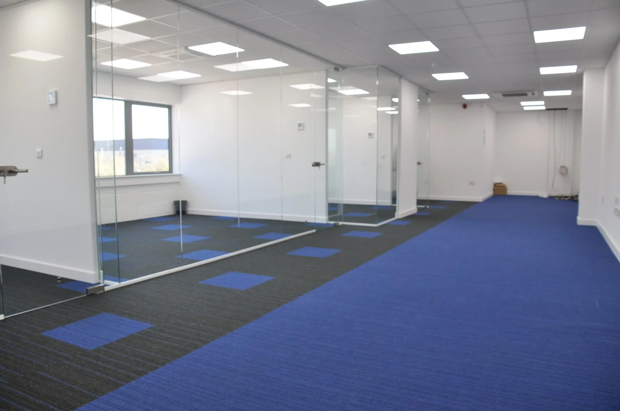 Designer office flooring with single glazed glass partition