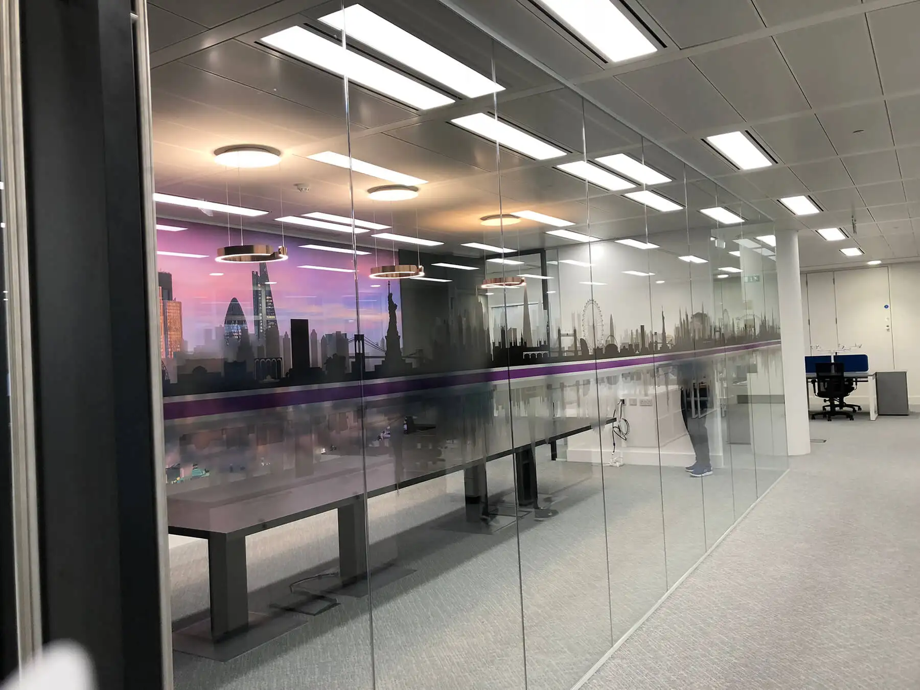 Frameless glass partitioned meeting space with designer walls