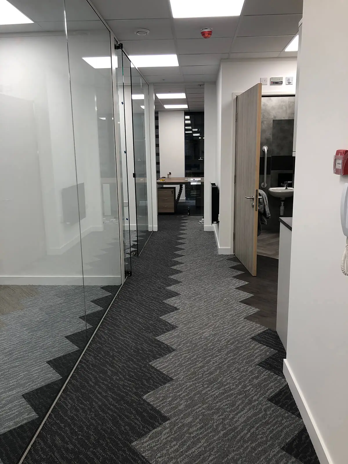 Full height frameless glass partitions in office