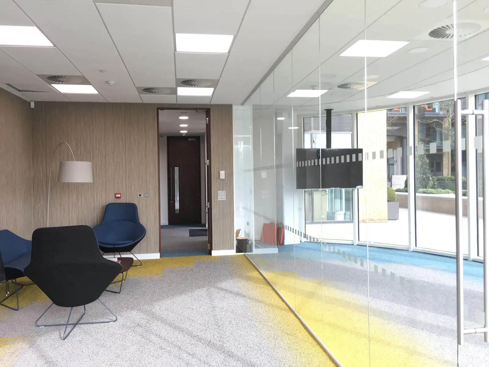 Gapuma office space with breakout chairs TV and dotted glass partition