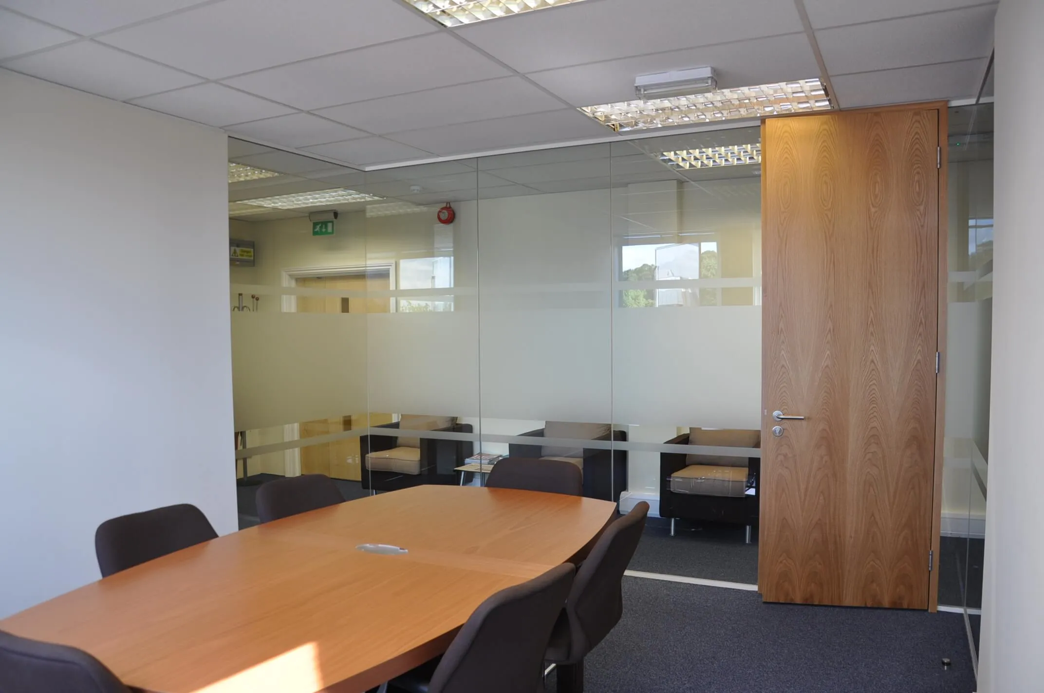 Jermyn Capital meeting room space with table chairs and glass partition with solid door