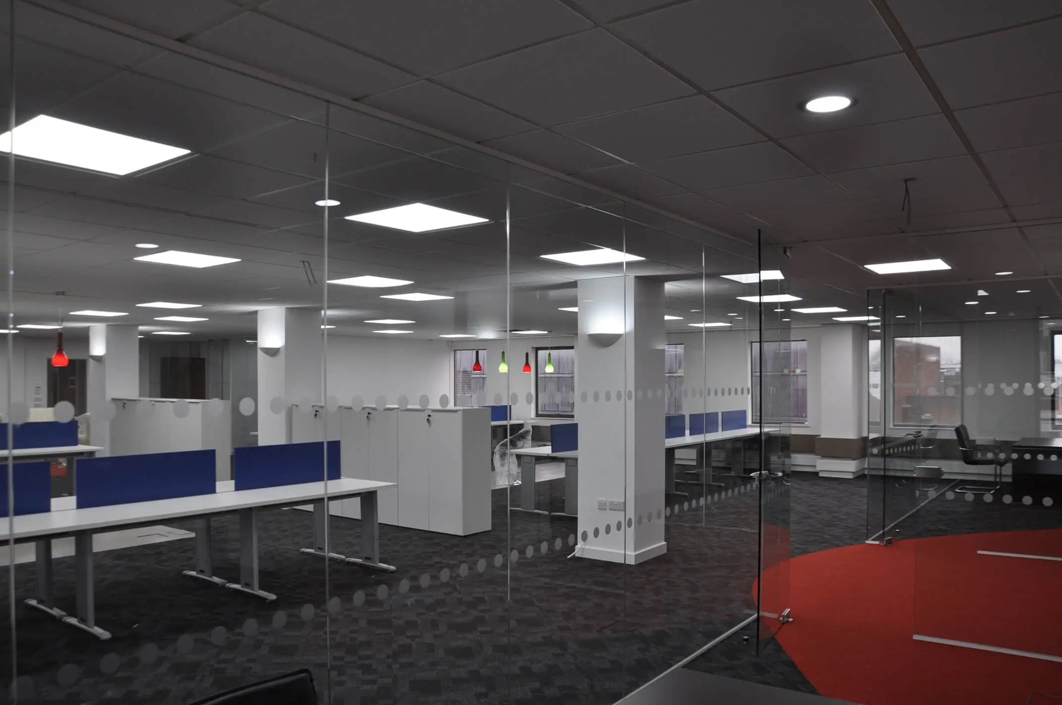Large office space divided with dotted frameless glass walls