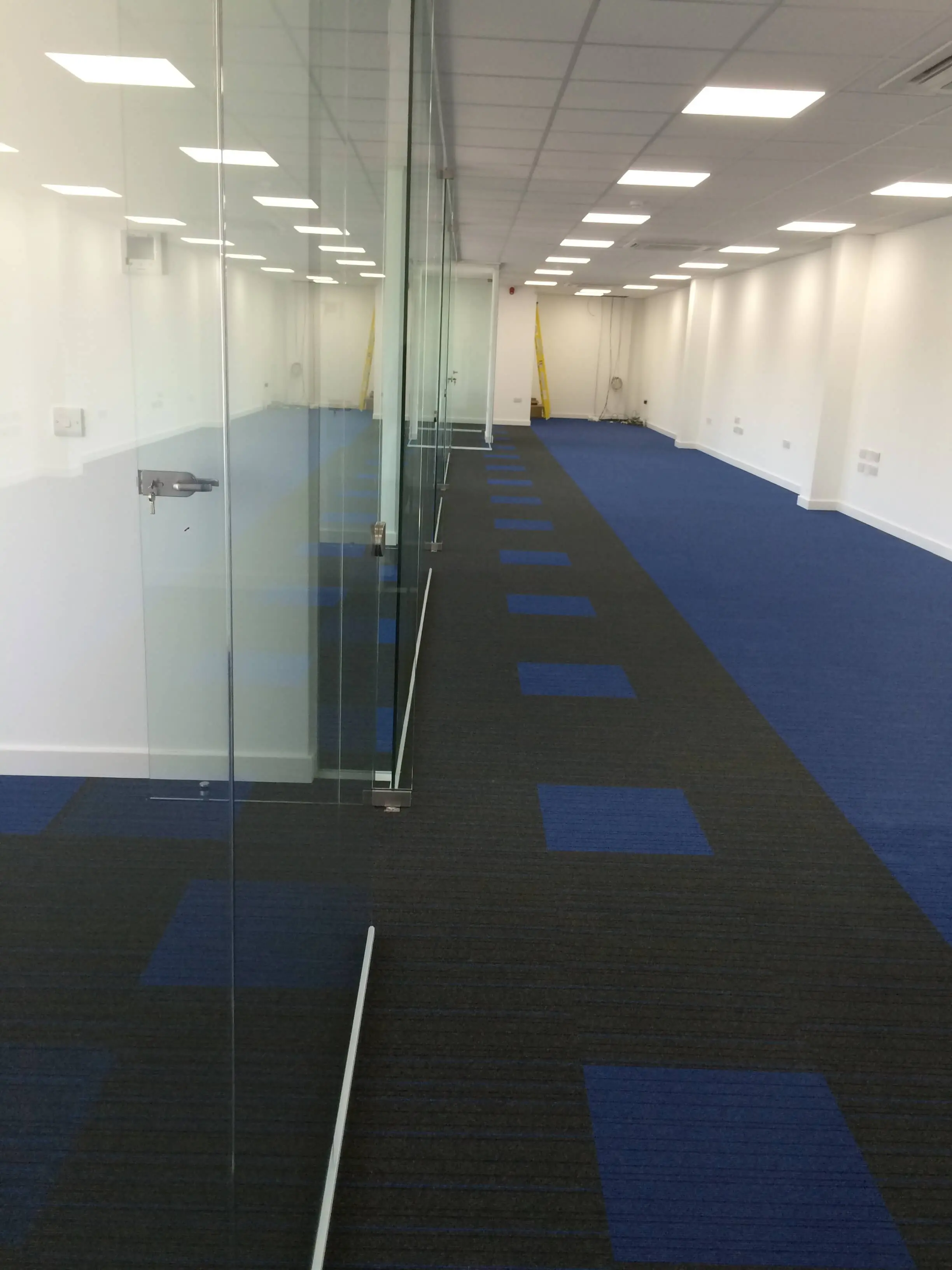 Large office space with glass partitions and lighting and designer floor