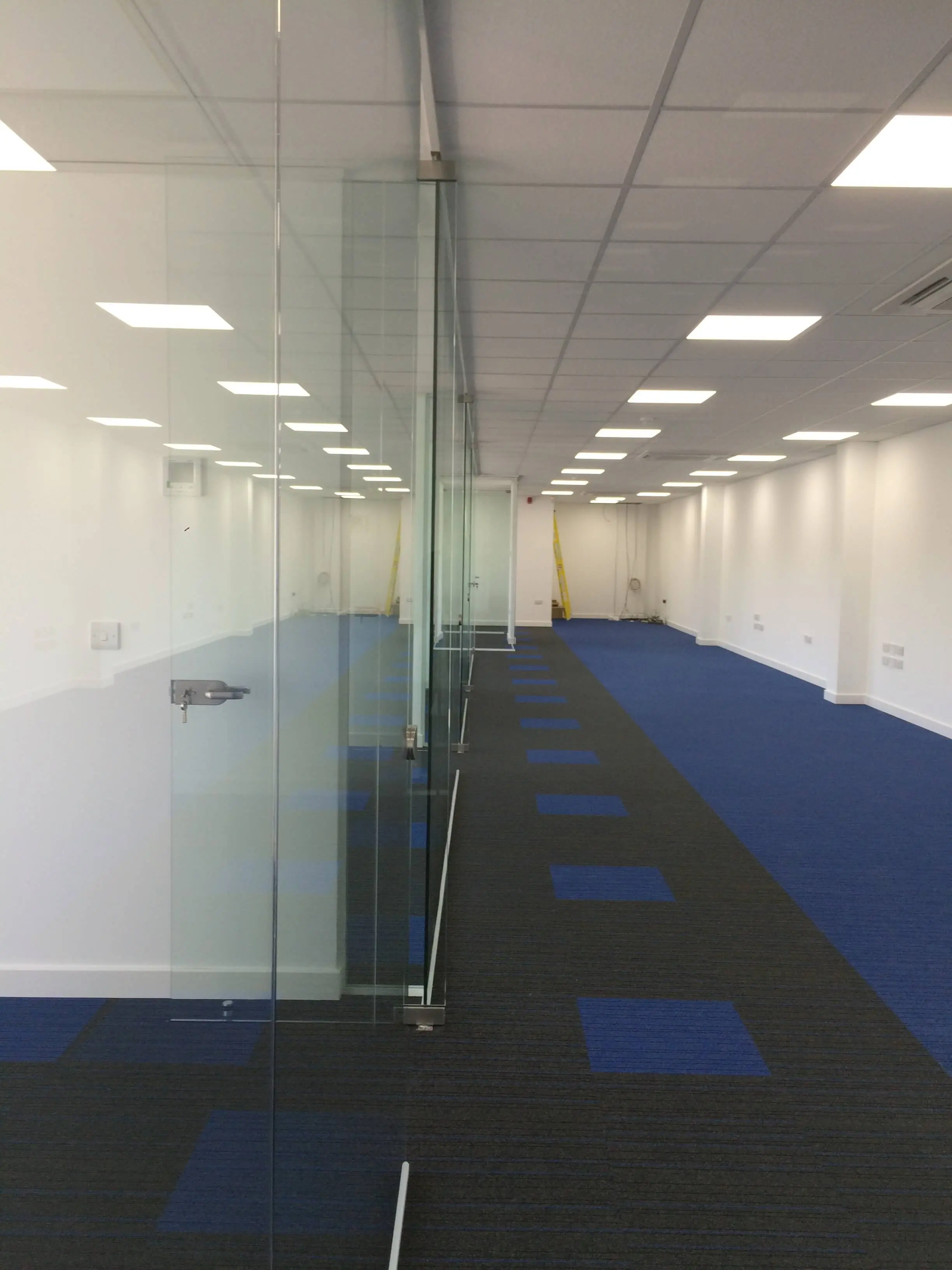 Large office space with glass partitions and lighting