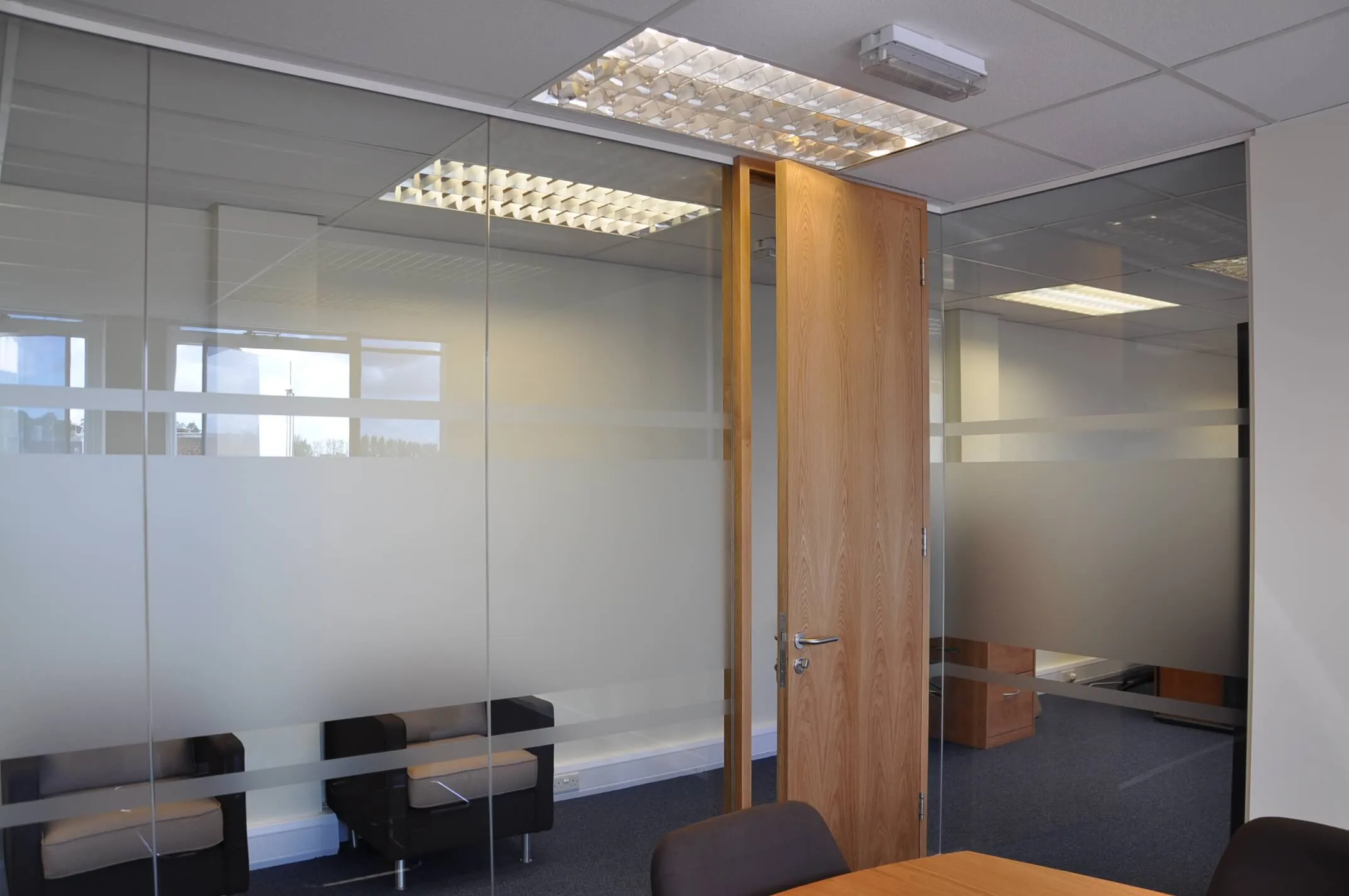 Manifested glass partitions with solid door for meeting space