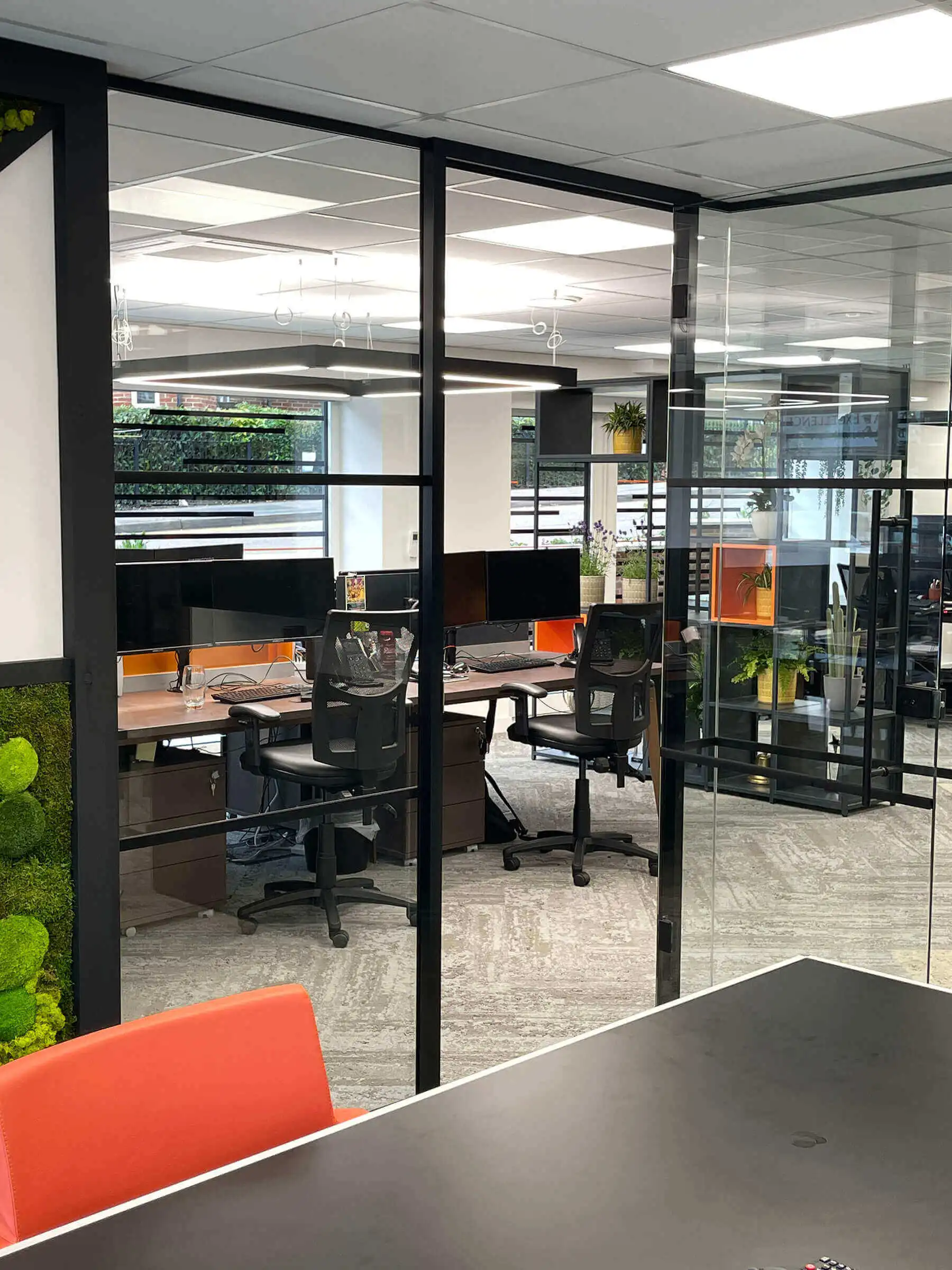 Meeting and co work space seperated with black framed glass partitions