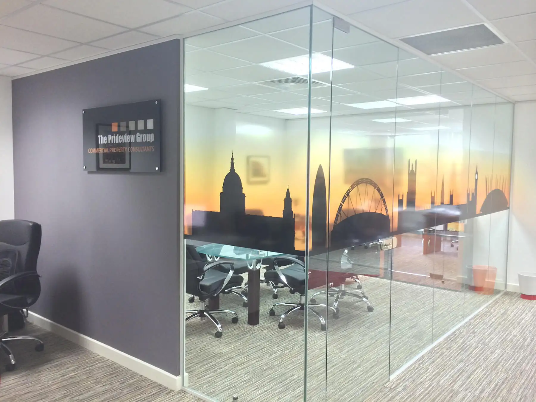 Meeting room with glass partitions and solid wall with logo