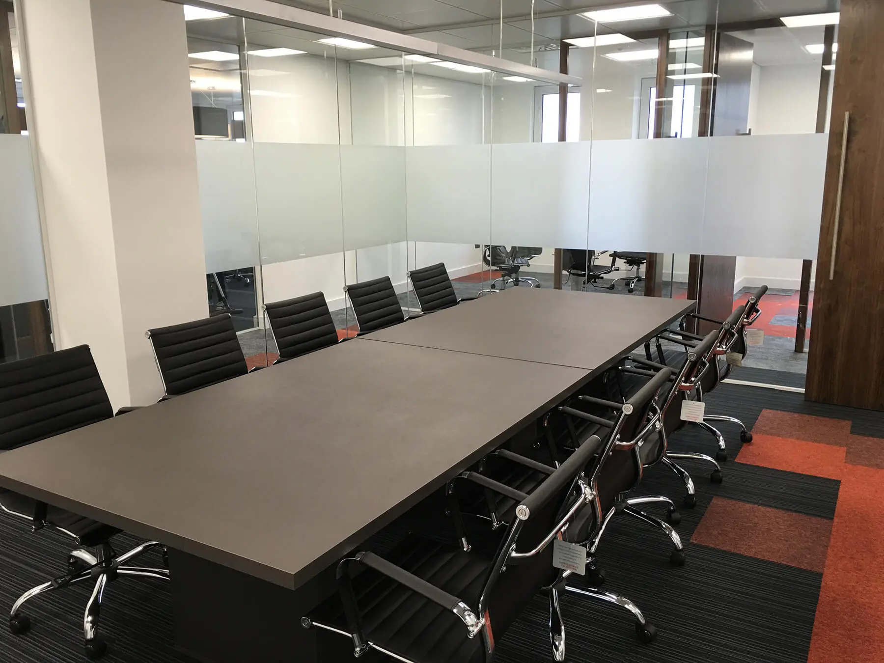 Meeting room with several black chairs and table