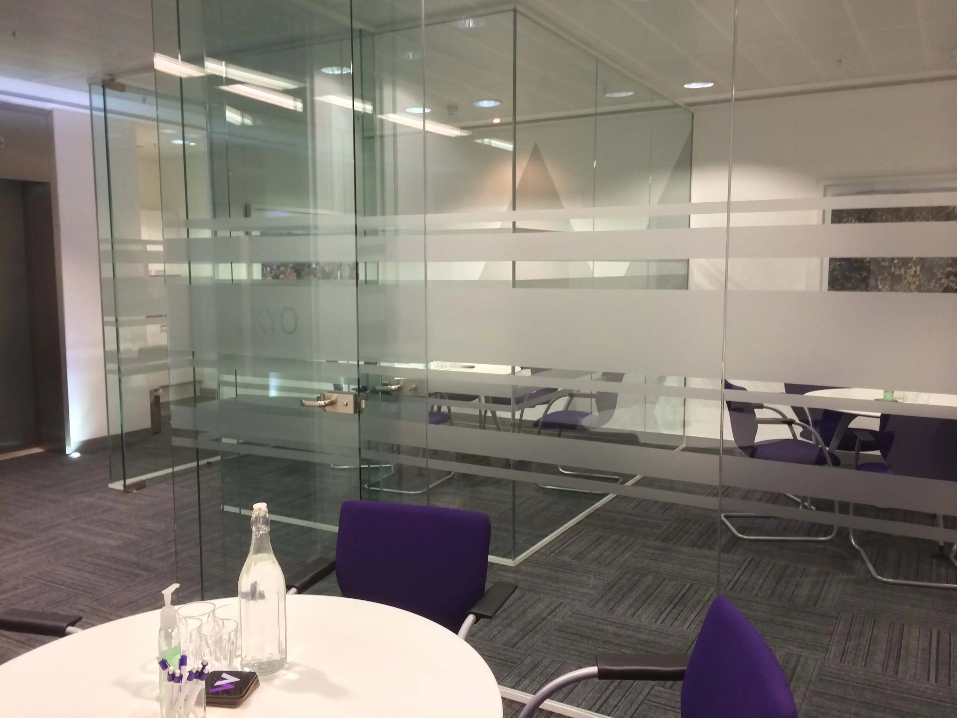 Meeting rooms with multiple round meeting tables with bottles on them