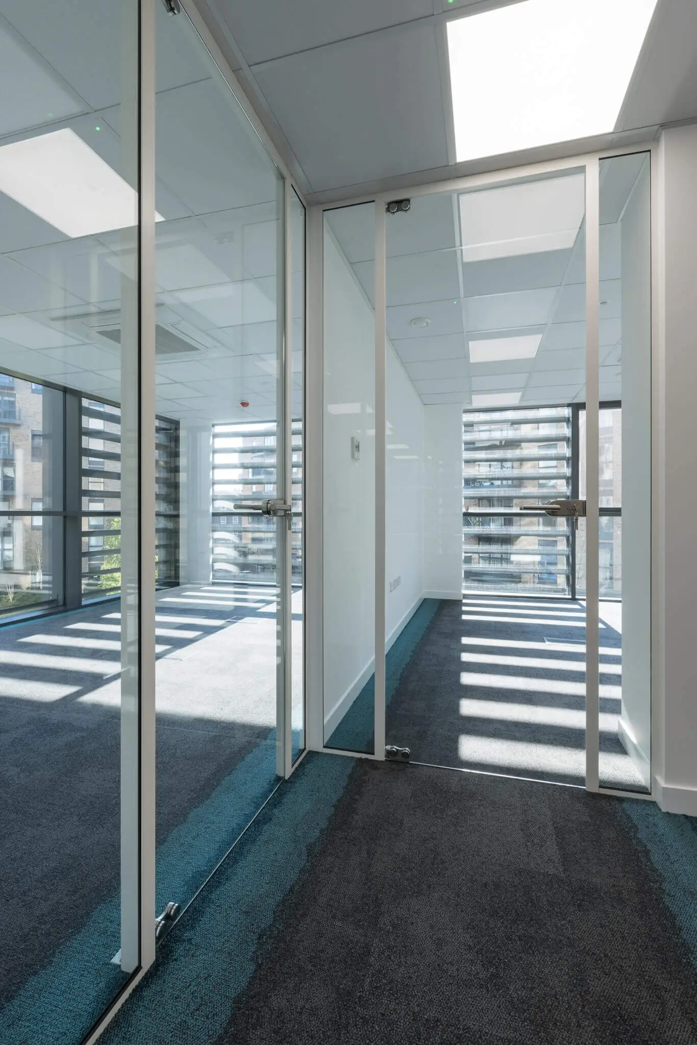 Office space lobby with framed glass doors and designer floors