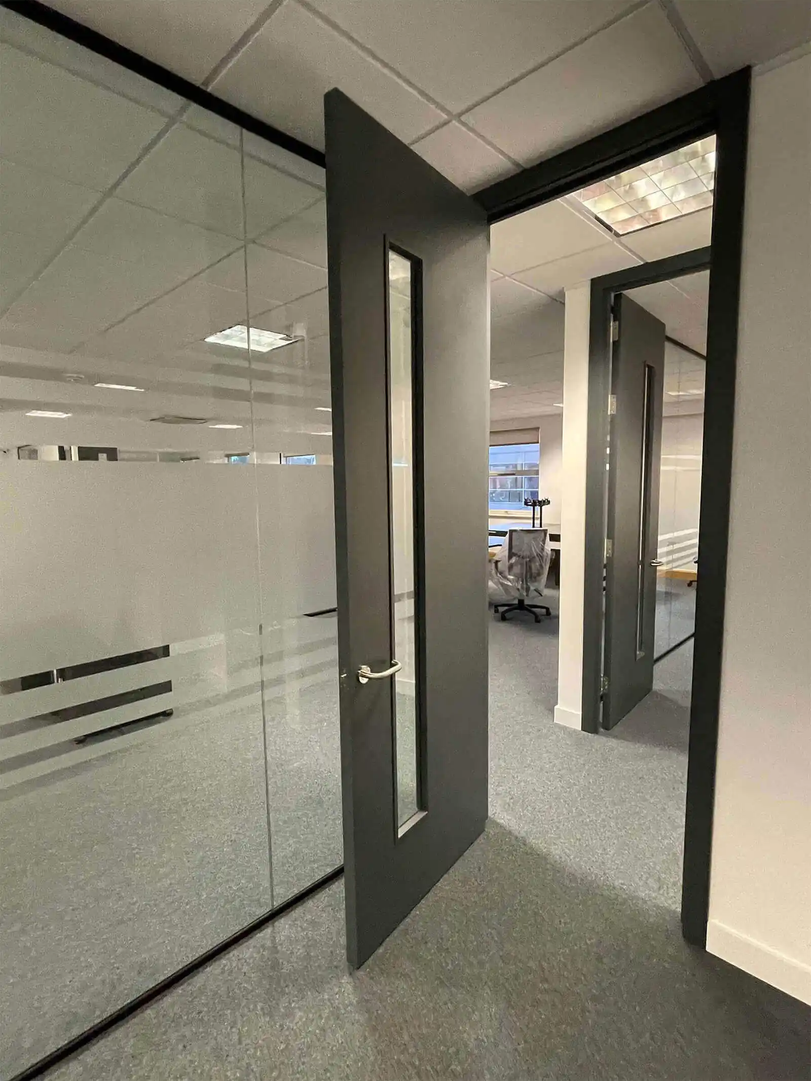 Office separated with glass partition with manifestations and solid door