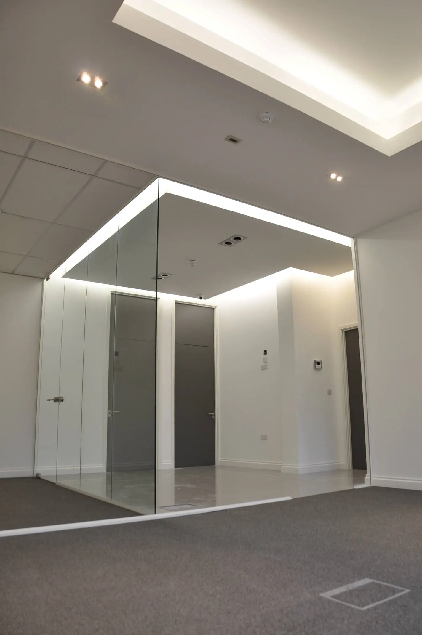 Office space partitions with frameless glass and lighting