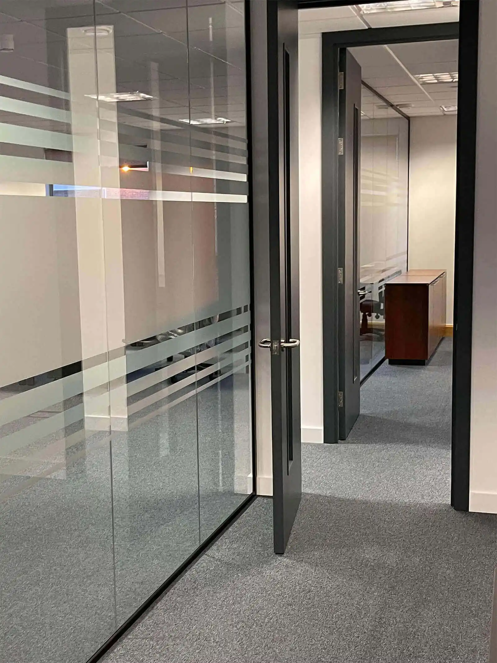 Office space separated with glass partitions with manifestations and solid door