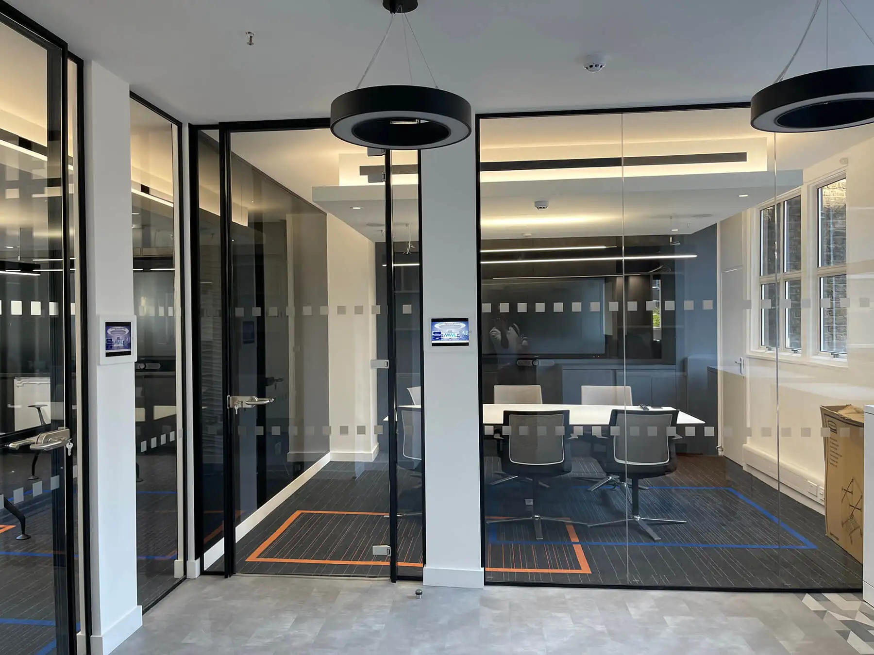 Office space with black framed glass partitions and designer flooring
