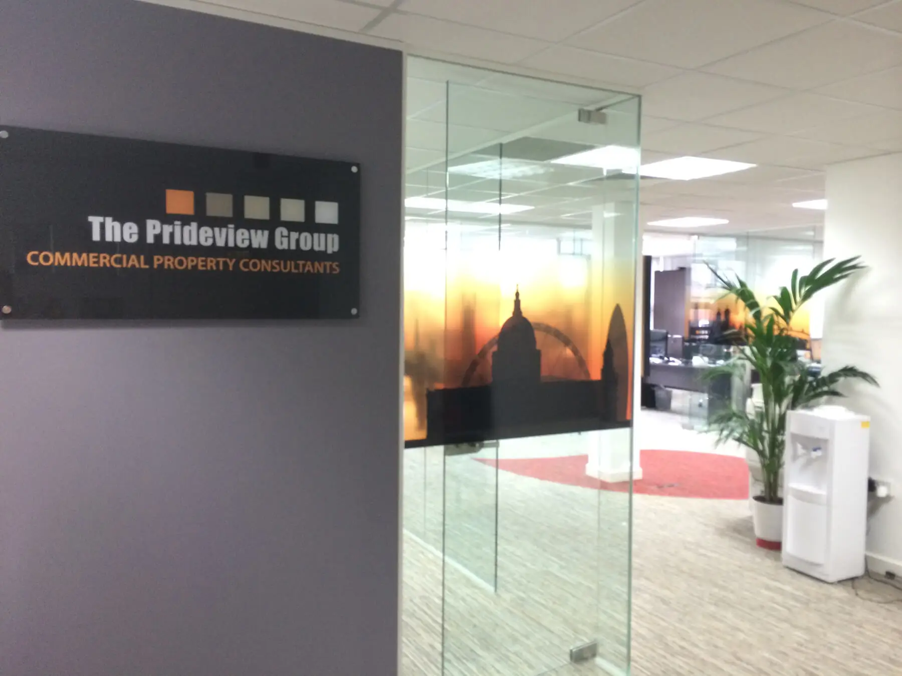Office space with glass partitions planters and logo design