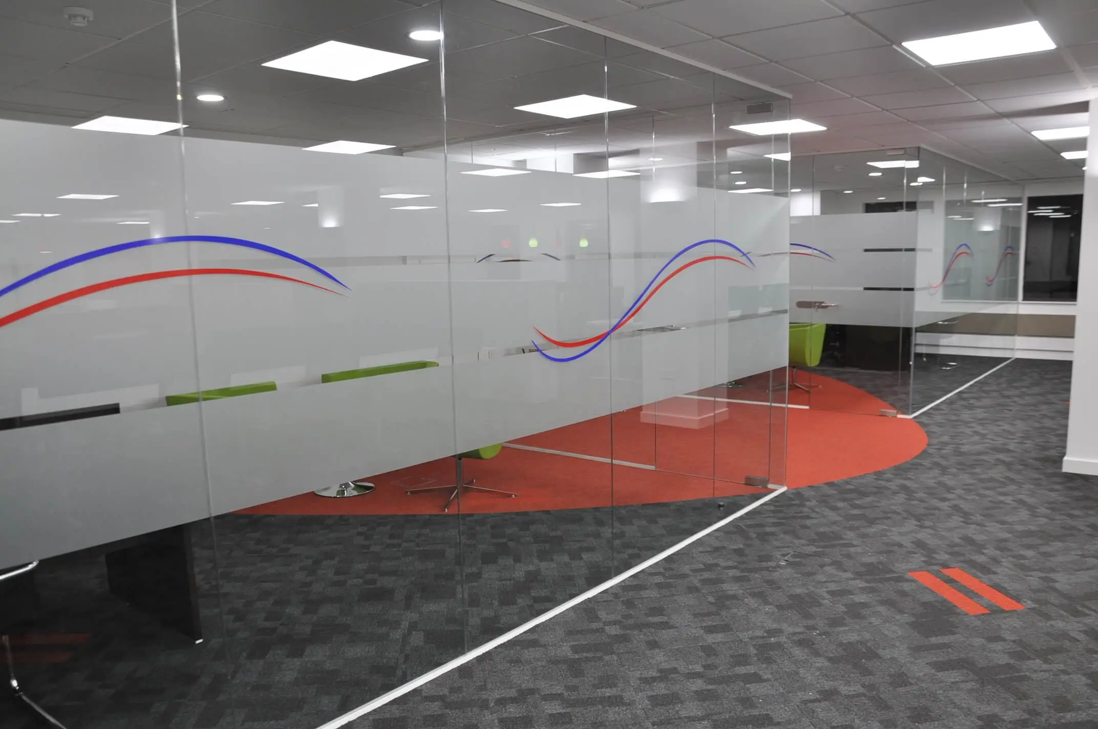 Office spaces divided with frameless glass partitions withdesigner manifestation