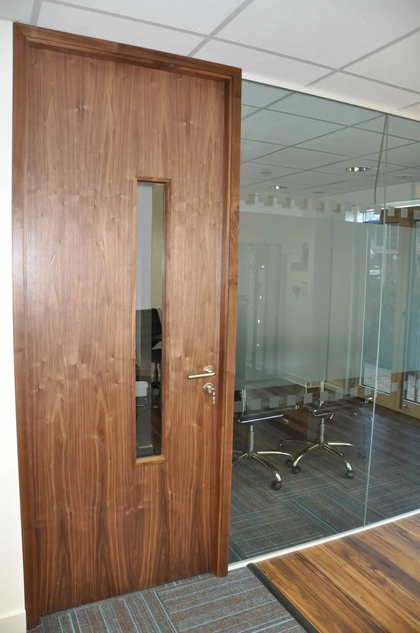 Office with glass partitions with solid door and designer floors