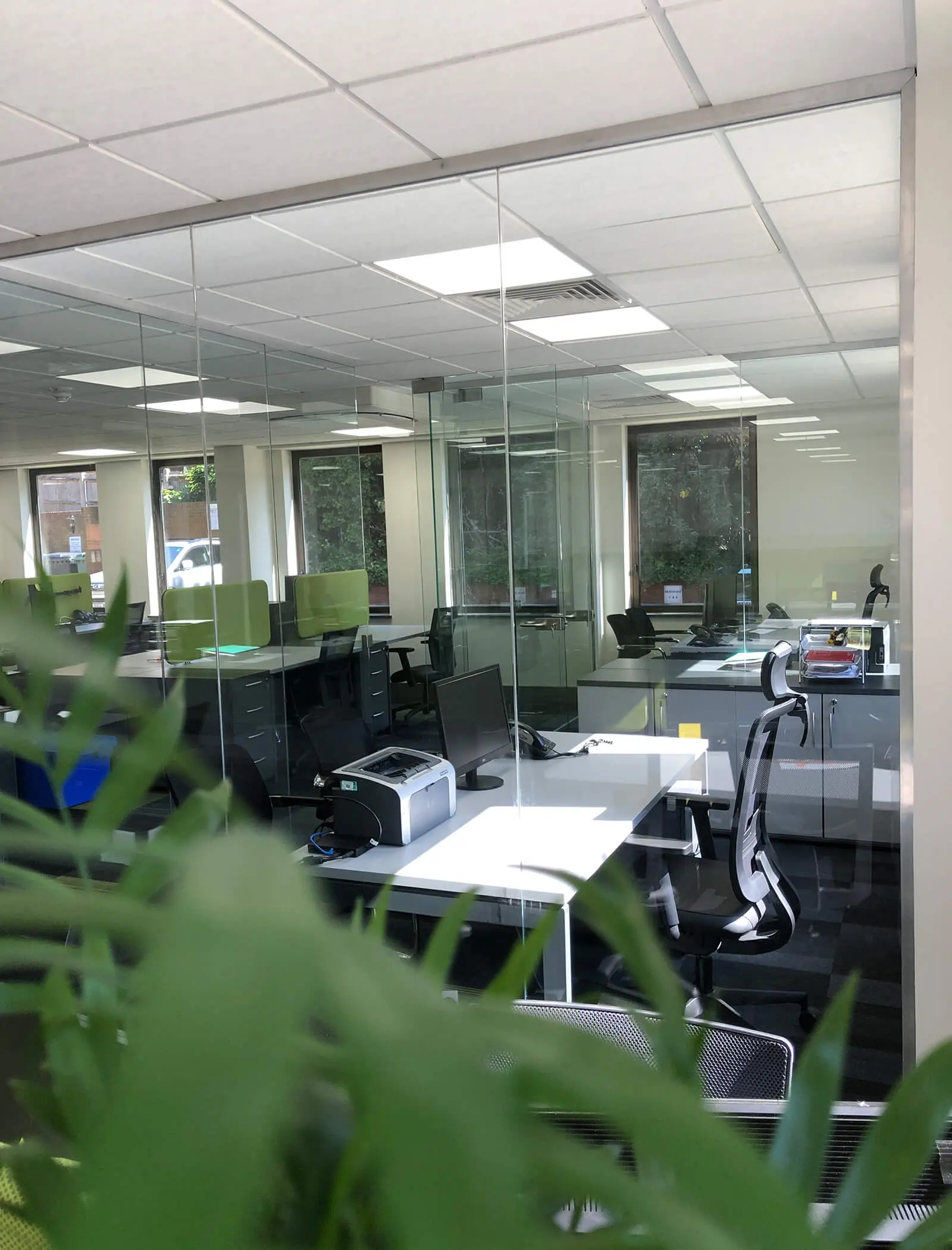 Planters in office space with designer furniture and glass doors