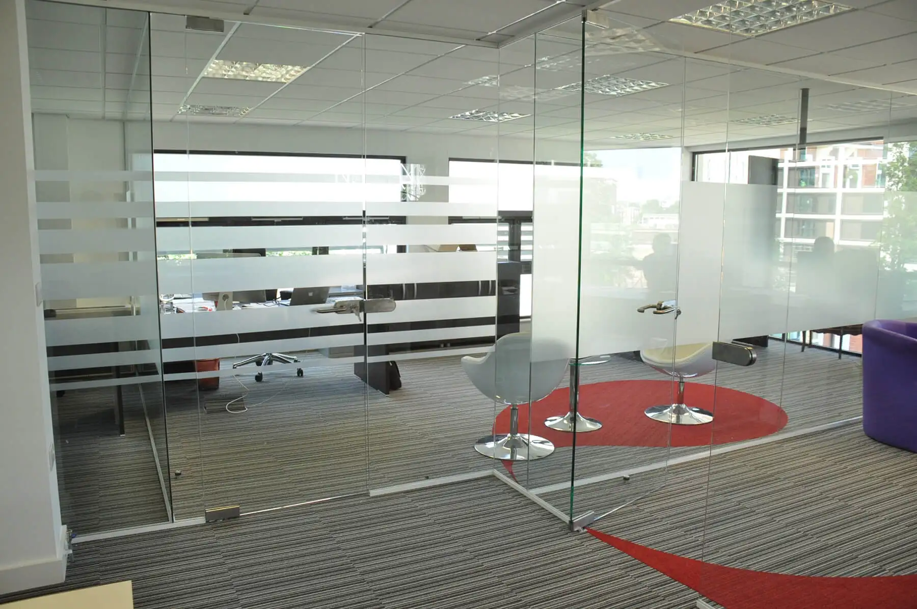 Single glazed frameless glass partitioning with designer floor