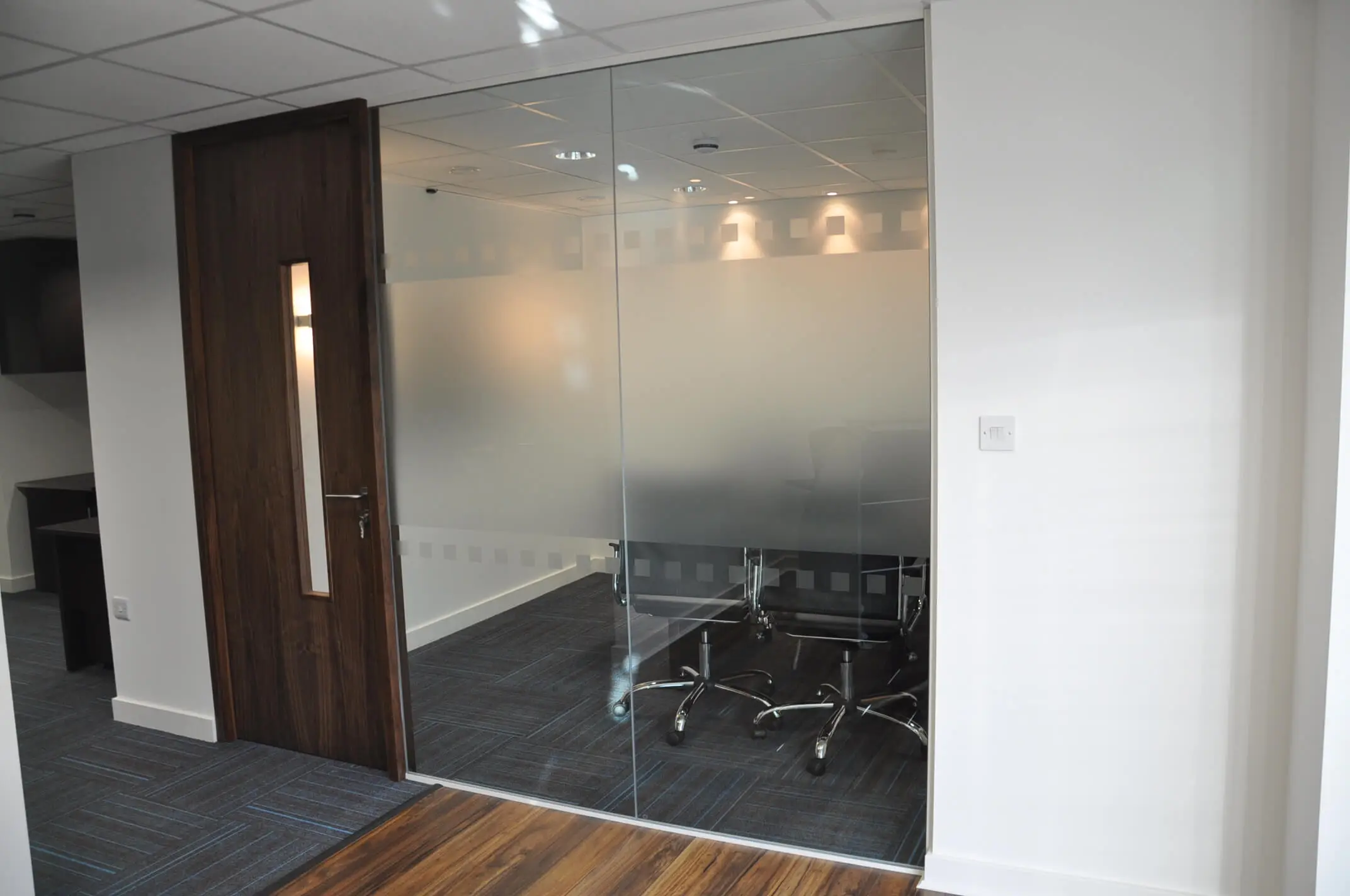 Single glazed manifested glass partitions in office meeting room