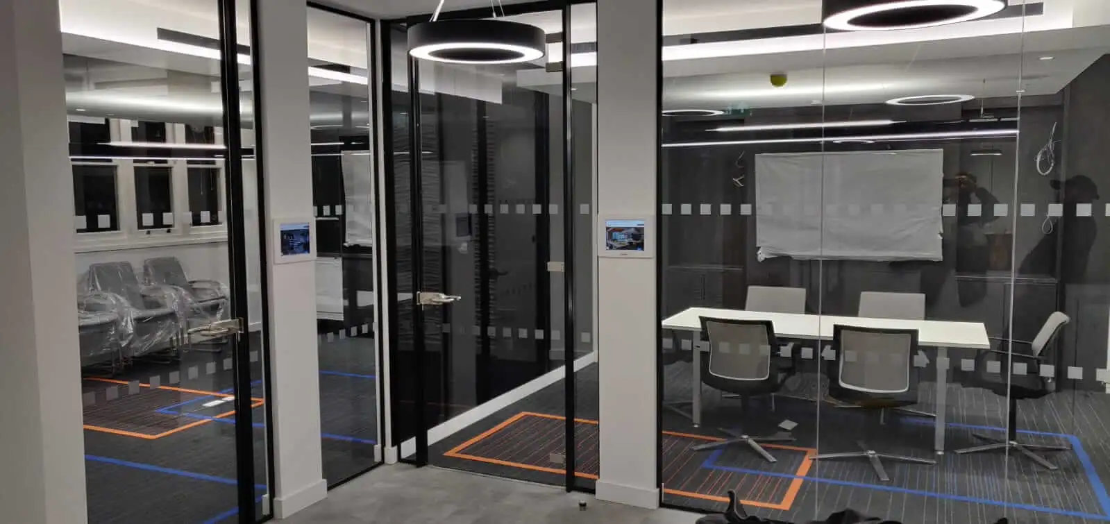 Waiting and meeting spaces with designer floors and black framed glass partitions