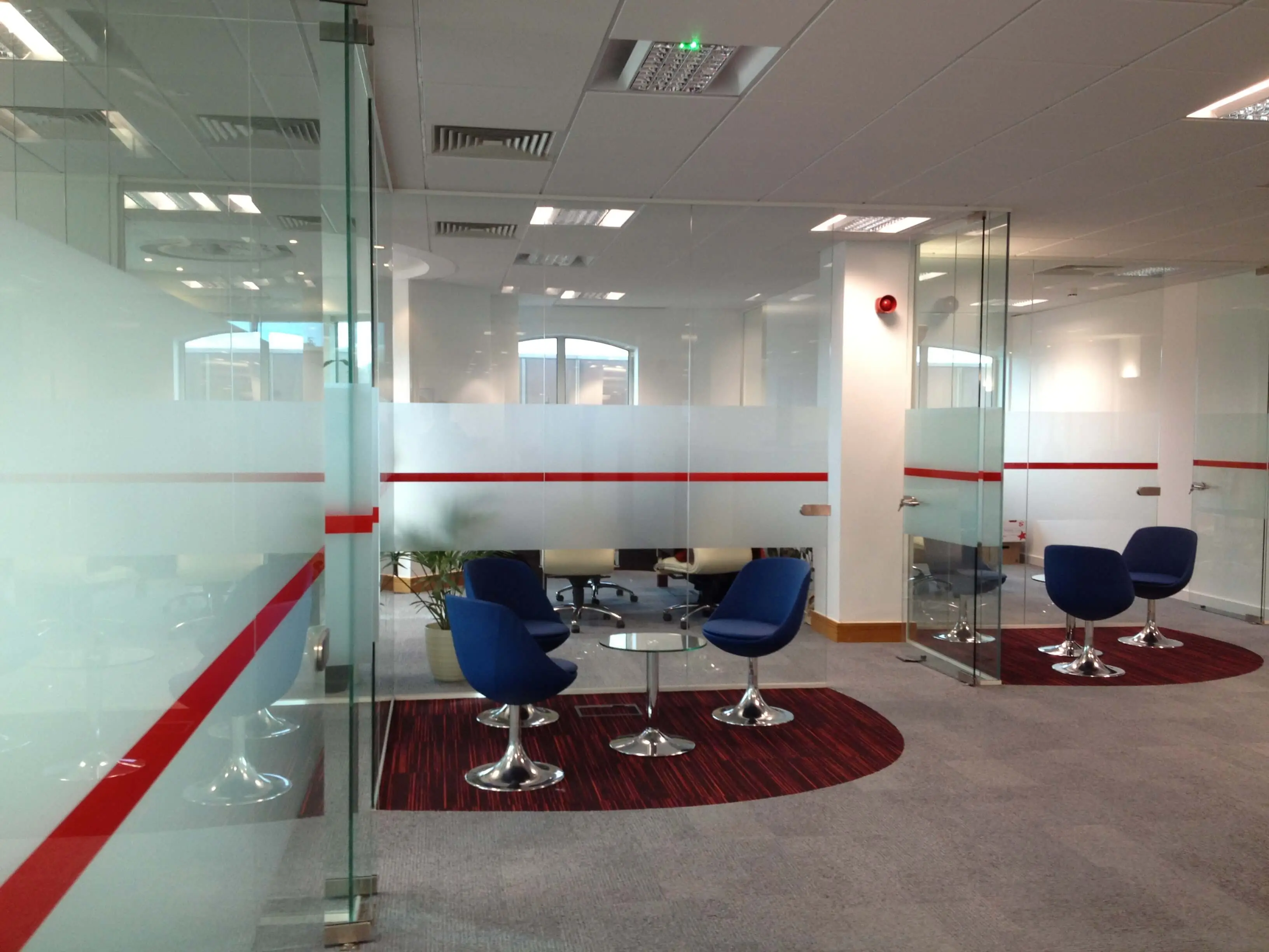 Waiting chairs coffee tables and glass partitions in office space