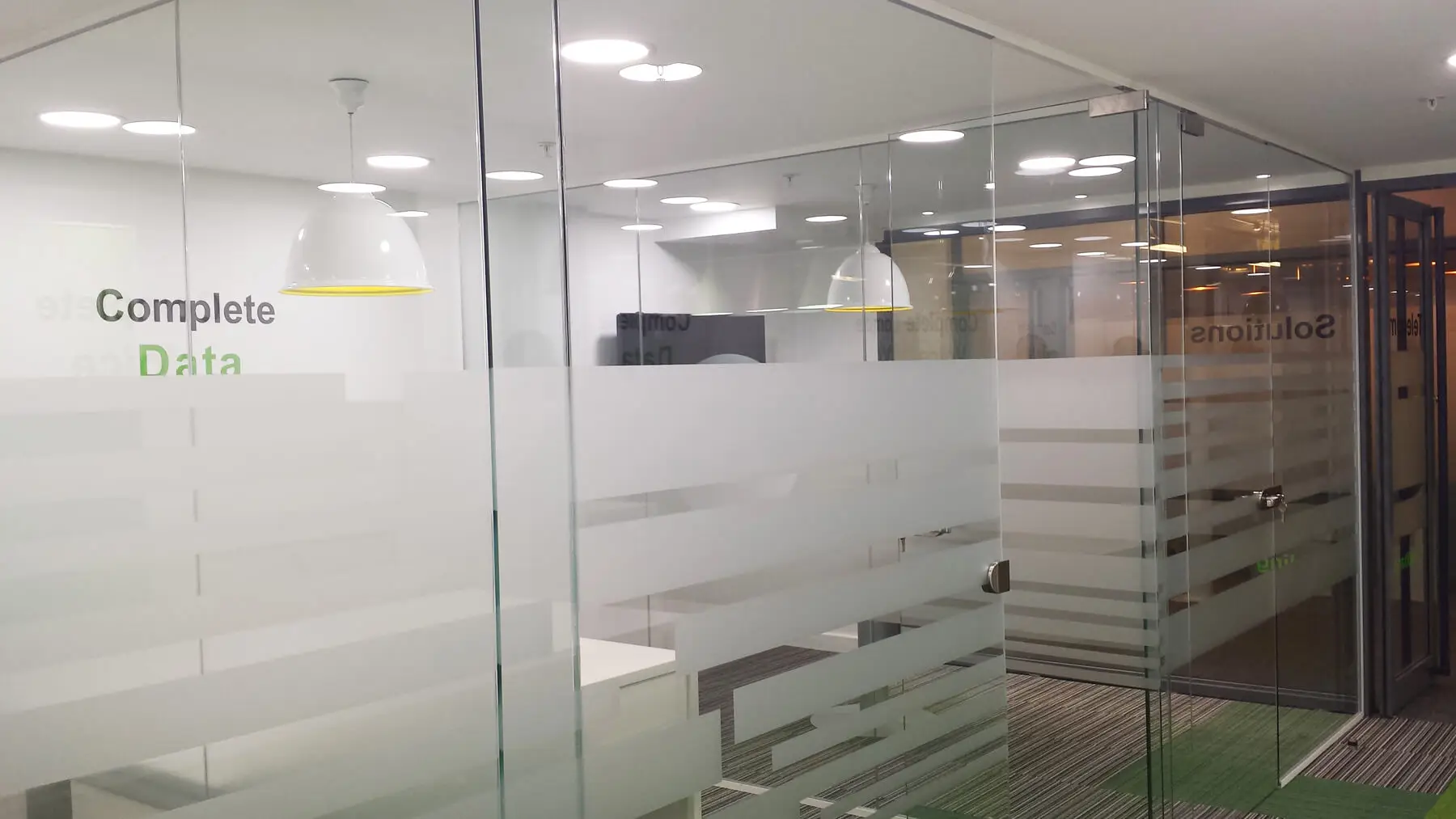 office space with frameless glass partitions and lighting lamps