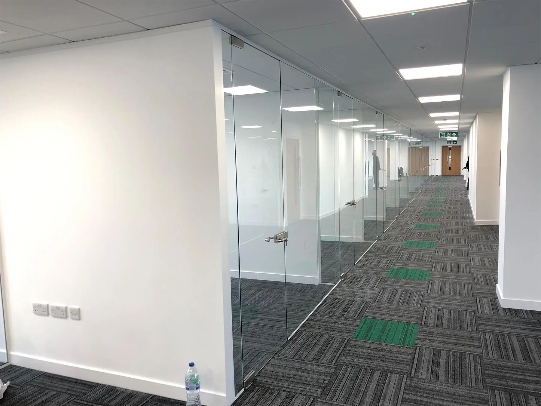 Designer flooring and frameless glass partitions in large office