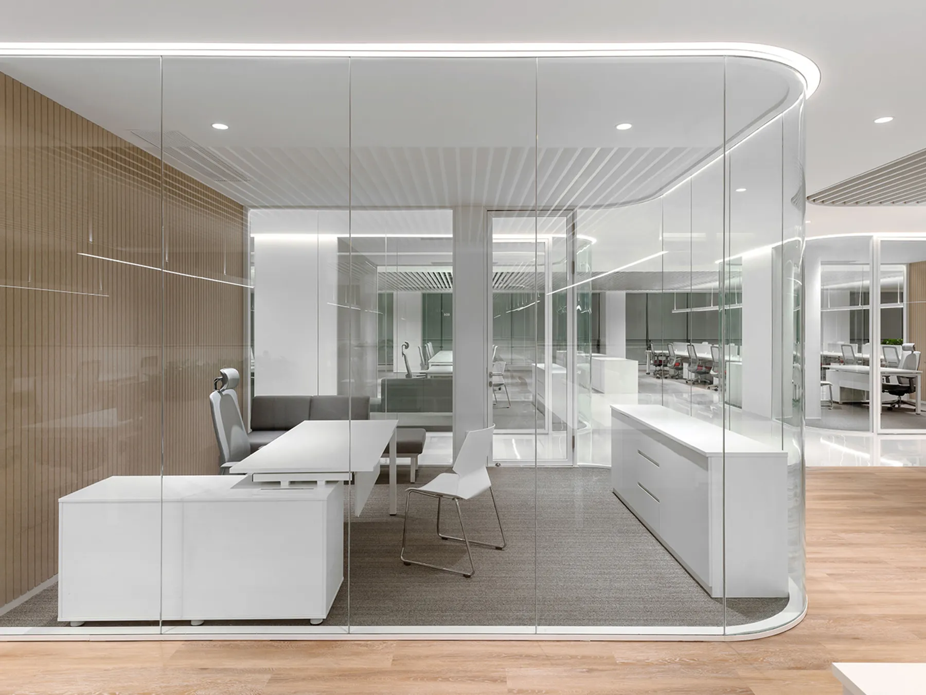 Executive space with desk chairs and curved glass partitions