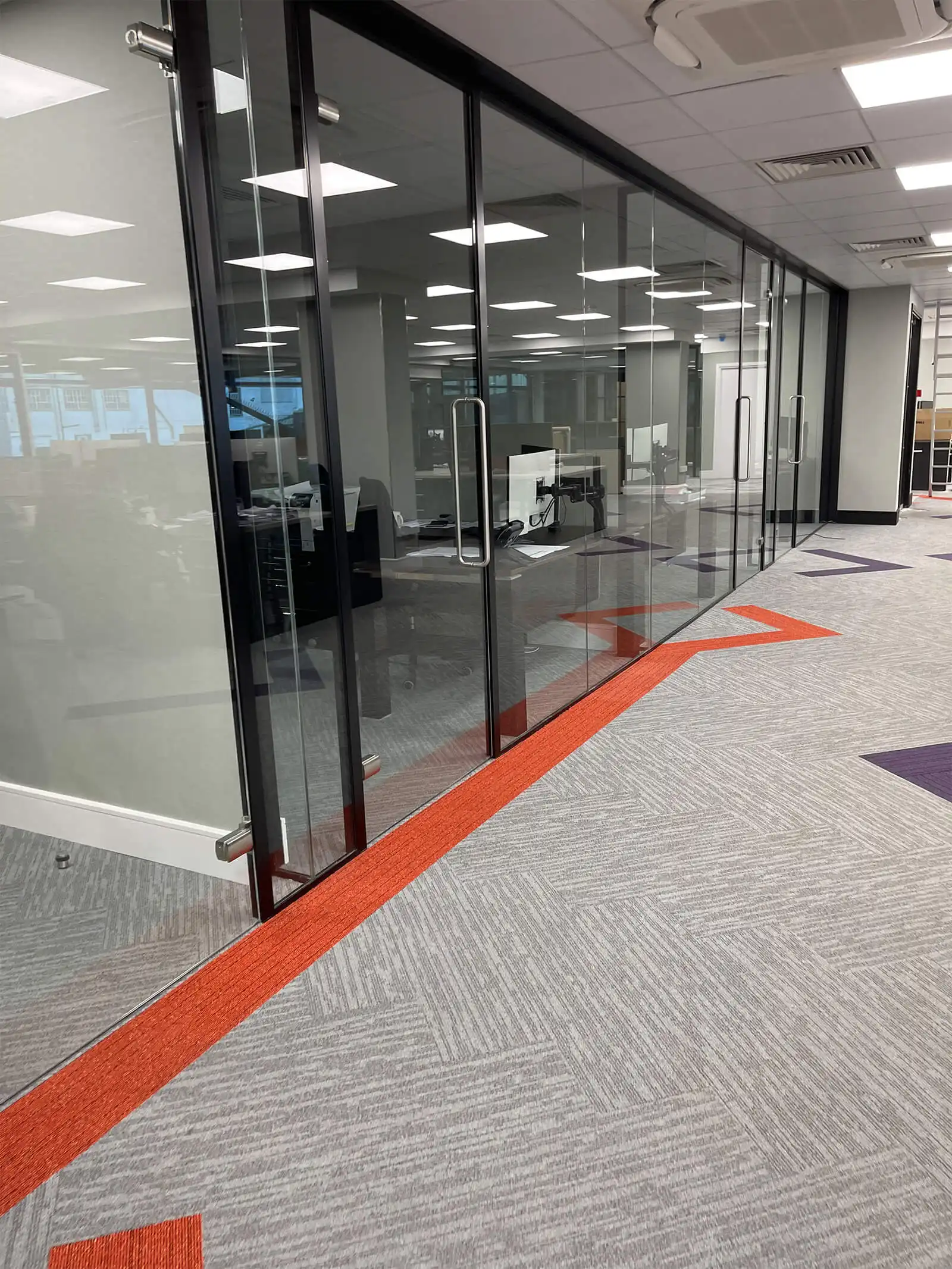 Framed glass doors in office with designer floor