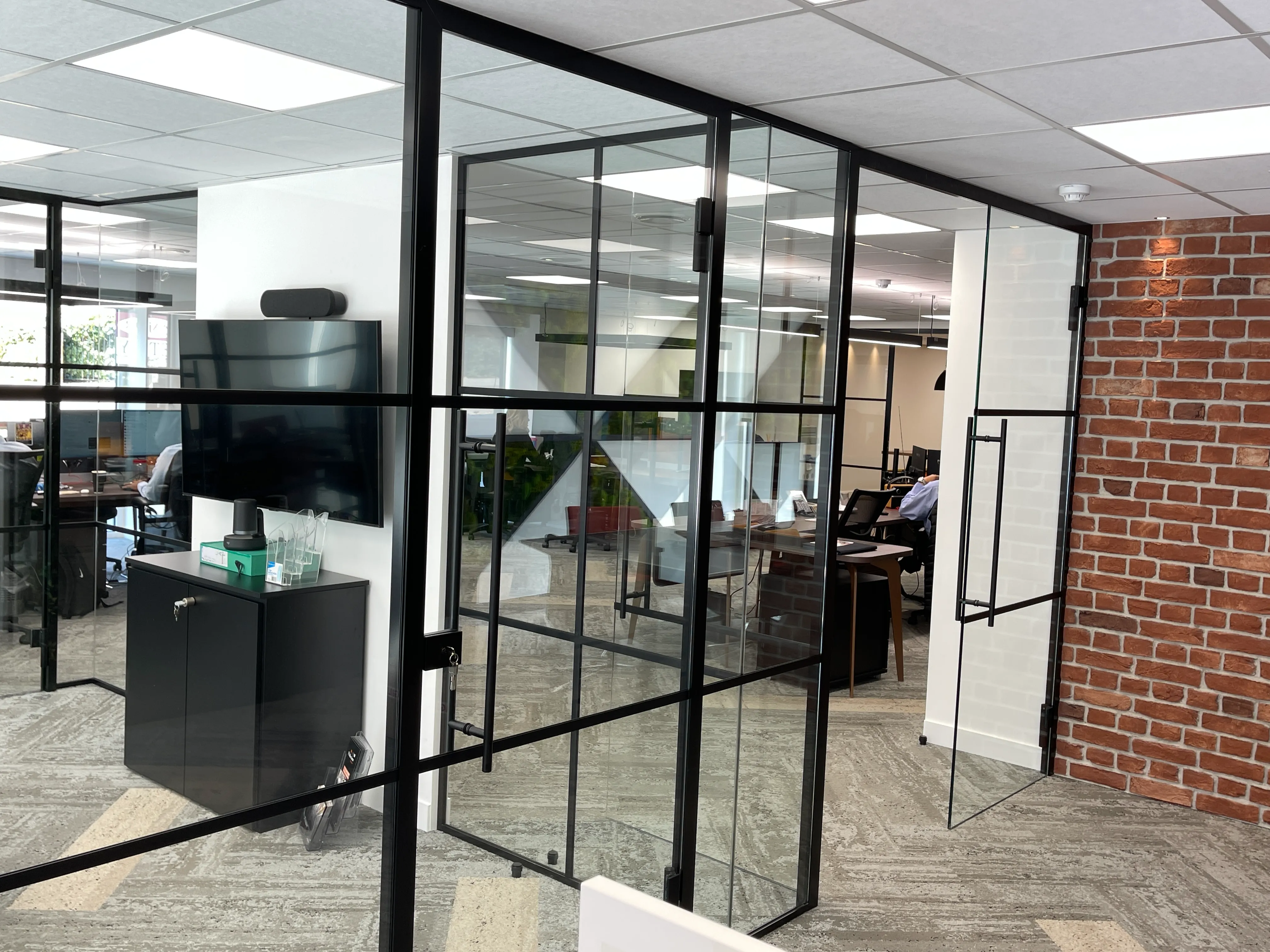 Office space divided with black framed glass partition