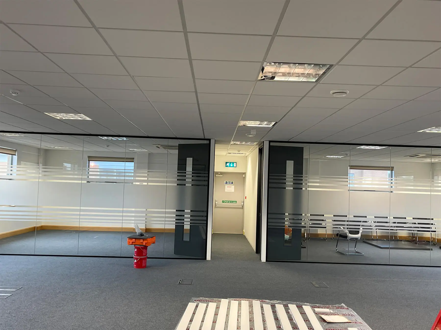 Office space under work with single glaze partitions with solid doors