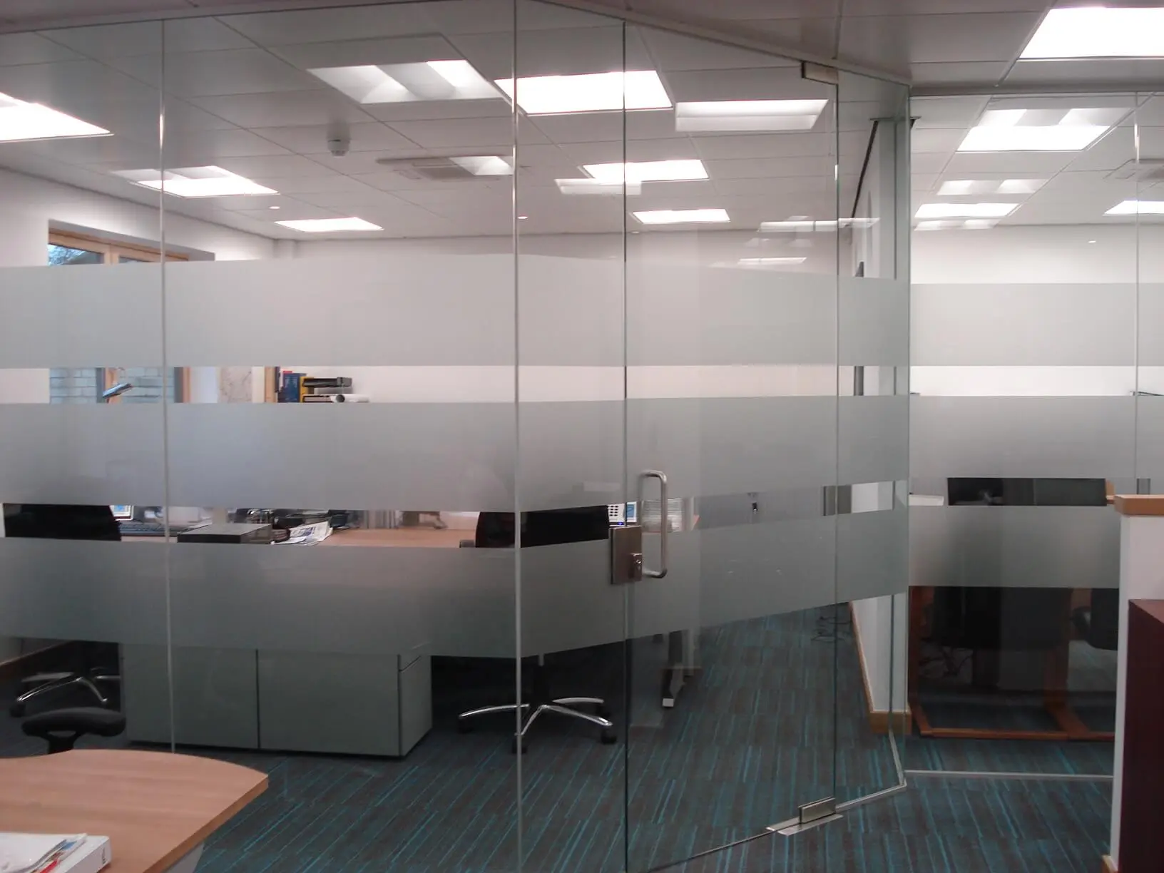 Office space with single glazed frameless glass doors and designer floors