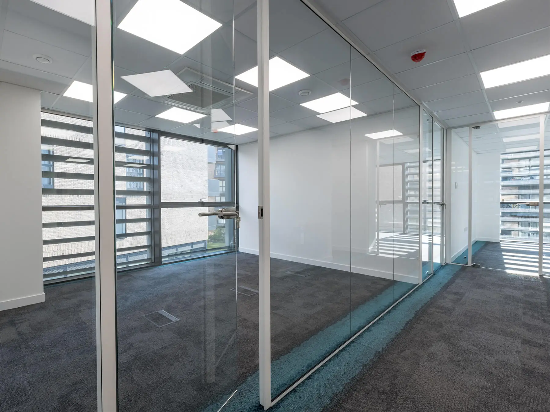 Office work space with single glazed partition with framed doors