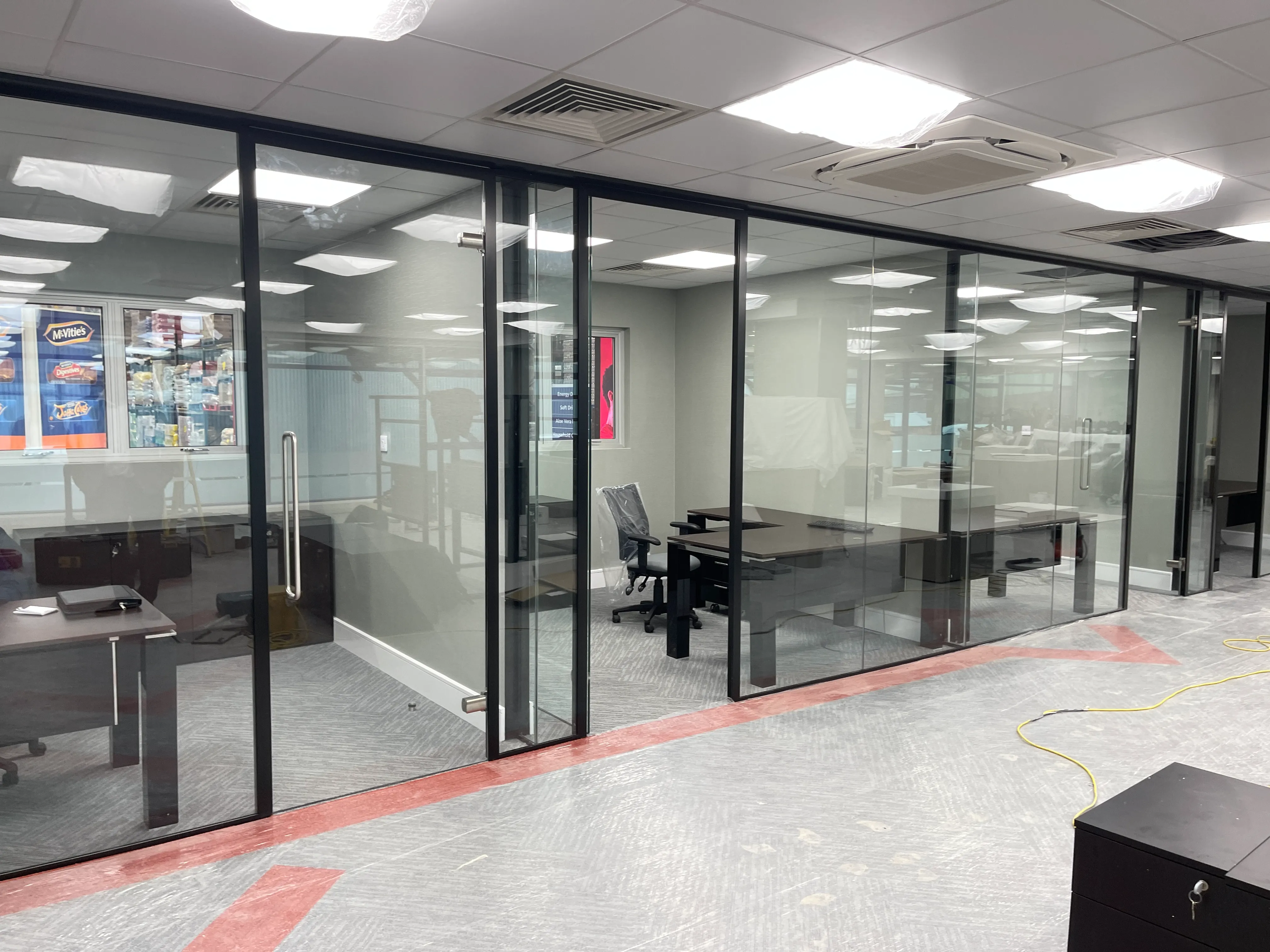 Private office workspace with black framed glass partitions