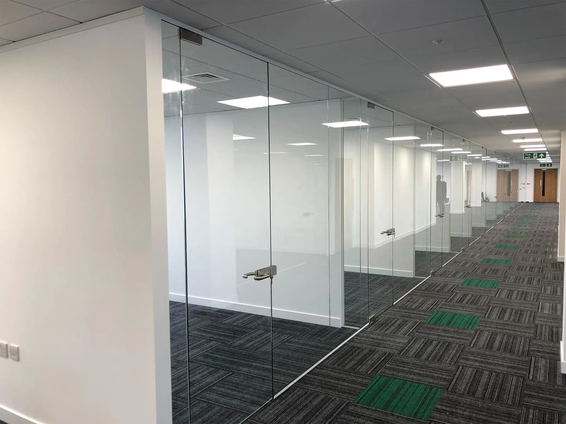 Single glazed frameless glass doors in office