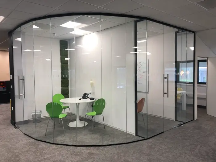 Small meeting space with glass walls and doors with furniture